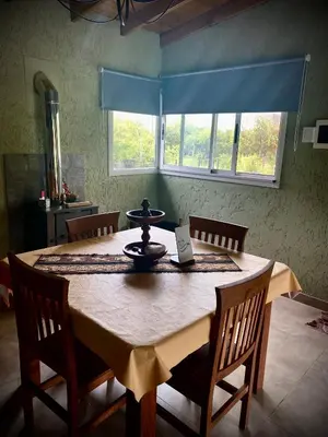 a dining room table with chairs and a blue window at Tierra de Zorros in Cortaderas