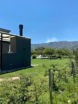 a house in a field with mountains in the background at Tierra de Zorros in Cortaderas