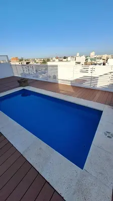 a blue swimming pool on the roof of a building at GEO departamento in Cordoba