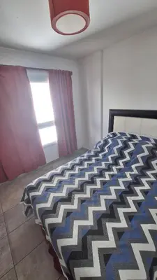 a bedroom with a bed with a blue and white comforter at GEO departamento in Cordoba