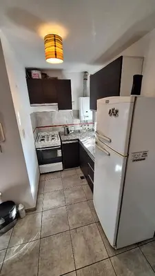 a kitchen with a white refrigerator and a stove at GEO departamento in Cordoba