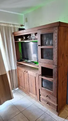 a large wooden entertainment center with a flat screen tv at GEO departamento in Cordoba