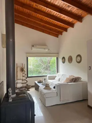 a living room with a white couch and a fireplace at Willert hauss in La Cumbrecita