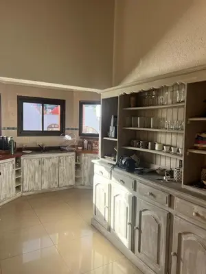 a large kitchen with white cabinets and shelves at Willert hauss in La Cumbrecita