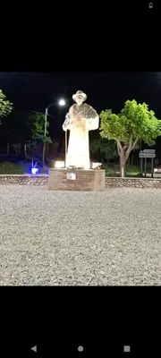 a statue in a park at night with a street light at El Crespín in San Lorenzo