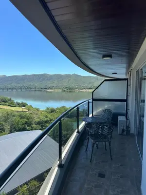 a balcony with a table and a view of a lake at Departamento en Veneto Village in Villa Parque Siquiman
