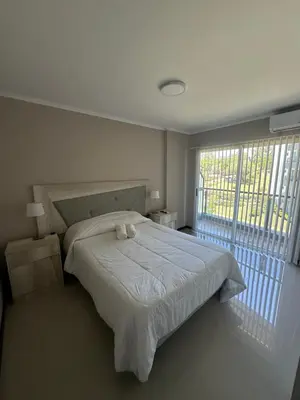 a bedroom with a bed and a large window at Departamento en Veneto Village in Villa Parque Siquiman