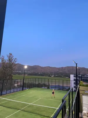 a person playing tennis on a tennis court at Departamento en Veneto Village in Villa Parque Siquiman