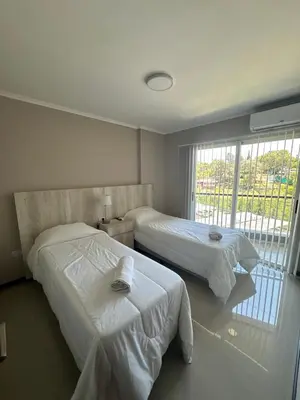 a bedroom with two beds and a window at Departamento en Veneto Village in Villa Parque Siquiman