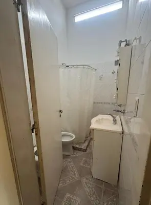 a white bathroom with a toilet and a sink at Depto 2 dormitorios, a 6 cuadras del rio y del centro in Villa Carlos Paz