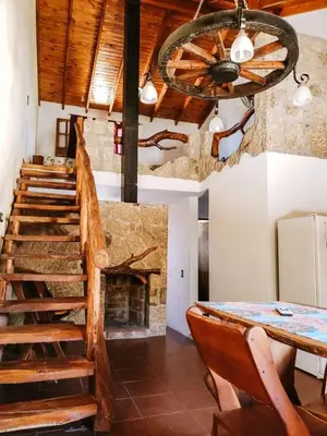 a dining room with a staircase and a fireplace at Complejo Sol del Valle in Mina Clavero