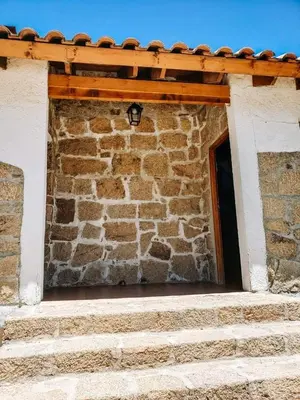 a brick building with a window and a roof at Complejo Sol del Valle in Mina Clavero