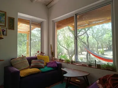 a living room with a purple couch and a window at Chañar in Villa de Las Rosas