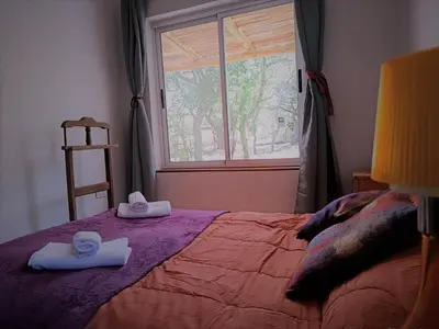 a bedroom with a bed with towels and a window at Chañar in Villa de Las Rosas