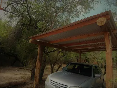 a car parked under a wooden pergola at Chañar in Villa de Las Rosas