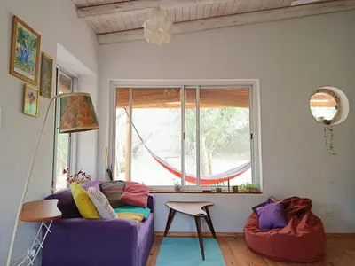 a living room with a purple couch and a window at Chañar in Villa de Las Rosas