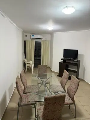 a living room with a glass table and chairs at Departamento Olivos IV in Villa Carlos Paz