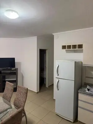 a kitchen with a white refrigerator and a couch at Departamento Olivos IV in Villa Carlos Paz