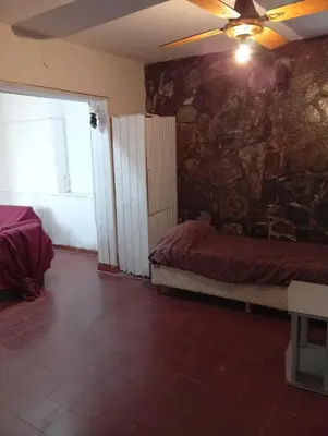 a room with two beds and a stone wall at Casa en Tanti in Tanti