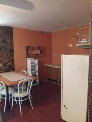 a kitchen with a table and a refrigerator at Casa en Tanti in Tanti