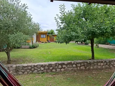 a view of a yard with trees and a house at Complejo Los Cuatro Elfos in La Estancia