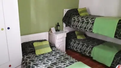 two beds in a room with green and black at Complejo Los Cuatro Elfos in La Estancia