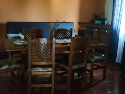 a dining room with a wooden table and chairs at Complejo Los Cuatro Elfos in La Estancia