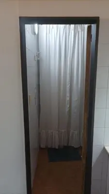 a bathroom with a shower with a white shower curtain at Villa Haus in Villa Carlos Paz