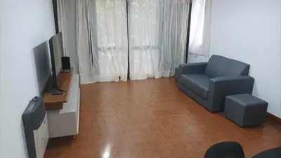 a living room with a blue chair and a television at Villa Haus in Villa Carlos Paz
