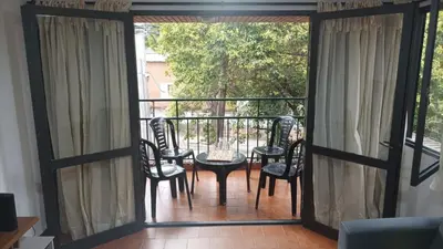 a room with a balcony with chairs and a table at Villa Haus in Villa Carlos Paz