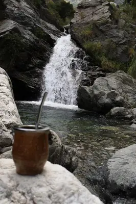 a cup sitting on a rock in front of a waterfall at Casa Merlo San Luis Barrio privado Solares del Valle in Merlo