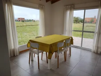 a dining room with a yellow table and chairs at Casa Merlo San Luis Barrio privado Solares del Valle in Merlo