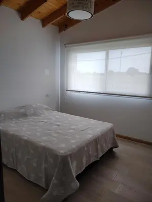 a bedroom with a bed in front of a window at Casa Merlo San Luis Barrio privado Solares del Valle in Merlo