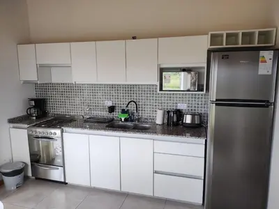 a kitchen with white cabinets and a stainless steel refrigerator at Casa Merlo San Luis Barrio privado Solares del Valle in Merlo