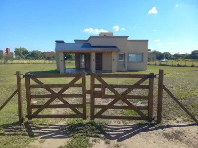 a wooden gate in front of a house at Casa Merlo San Luis Barrio privado Solares del Valle in Merlo
