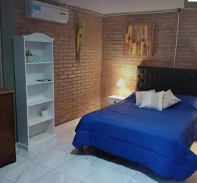 a bedroom with a blue bed and a brick wall at Posadas La Paz in San Antonio de Arredondo