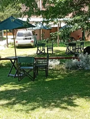 a group of picnic tables and umbrellas in a park at Posadas La Paz in San Antonio de Arredondo