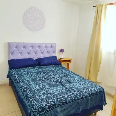 a bedroom with a bed with a blue comforter at Abuela Angélica in San Lorenzo