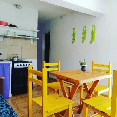a kitchen with a wooden table and yellow chairs at Abuela Angélica in San Lorenzo
