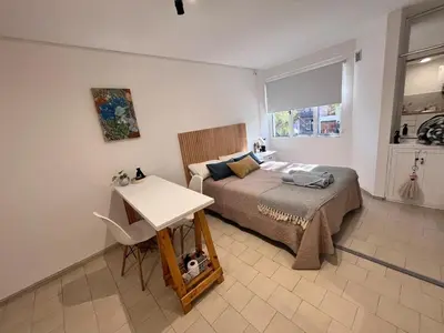 a bedroom with a bed and a table and a window at Monoambiente para 2 personas Zona Centro in Cordoba