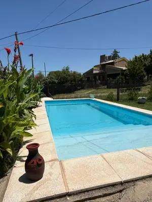 a swimming pool with a vase sitting next to it at El Algarrobo in Villa del Dique