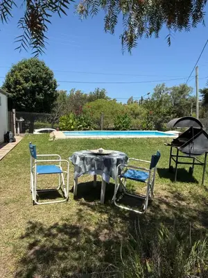 a table and two chairs and a swimming pool at El Algarrobo in Villa del Dique