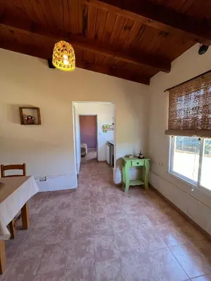 a living room with a table and a lamp at Departamento de las sierras in Embalse