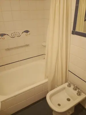 a bathroom with a tub and a toilet and a sink at Departamento amoblado de lujo con pileta y gym in Cordoba