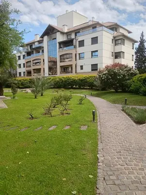 a building with a grassy area in front of a building at Departamento amoblado de lujo con pileta y gym in Cordoba