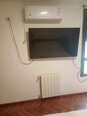 a wall with a microwave and a heater in a room at Departamento amoblado de lujo con pileta y gym in Cordoba