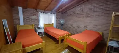 a room with two beds and a brick wall at Cabañas Dionisio in Nono