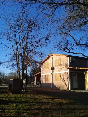 a small white building in a field with a tree at Cabañas Dionisio in Nono