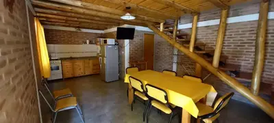 a kitchen and dining room with a yellow table and chairs at Cabañas Dionisio in Nono