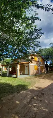 a house with a garage and a tree at Cabañas Dionisio in Nono